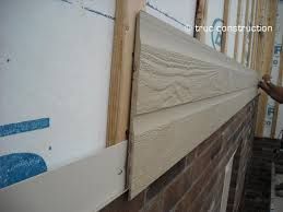 Une personne installe un revêtement sur un mur de briques.