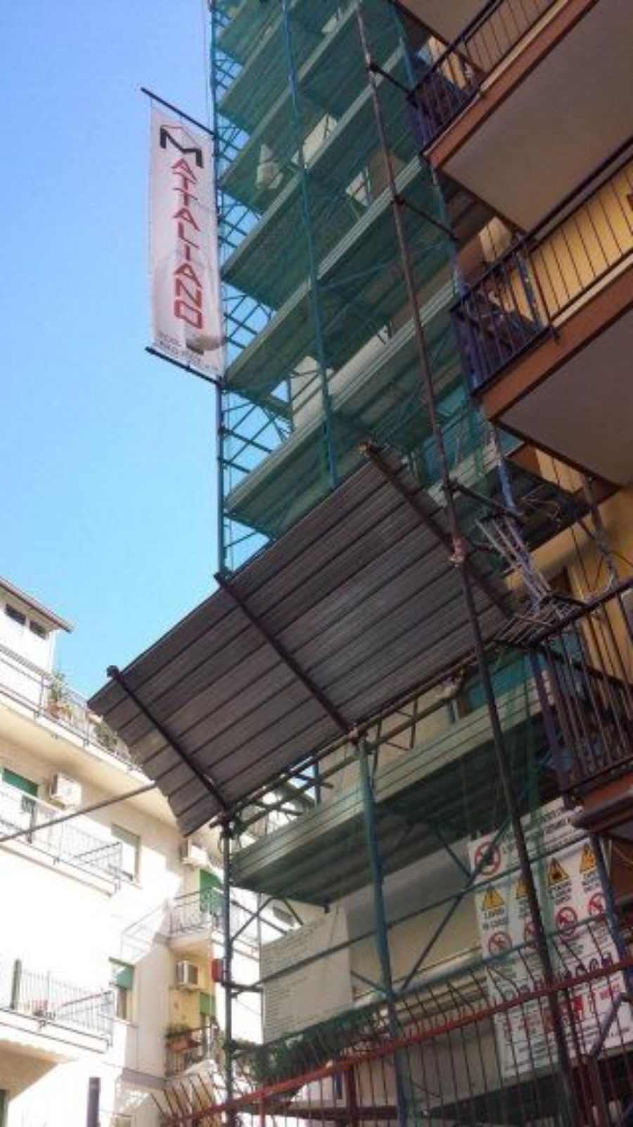 Impalcatura su edificio con striscione con la scritta 