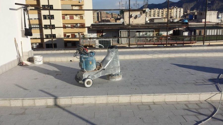 Lucidatrice per pavimenti su un terrazzo sul tetto, con vista sulla città.