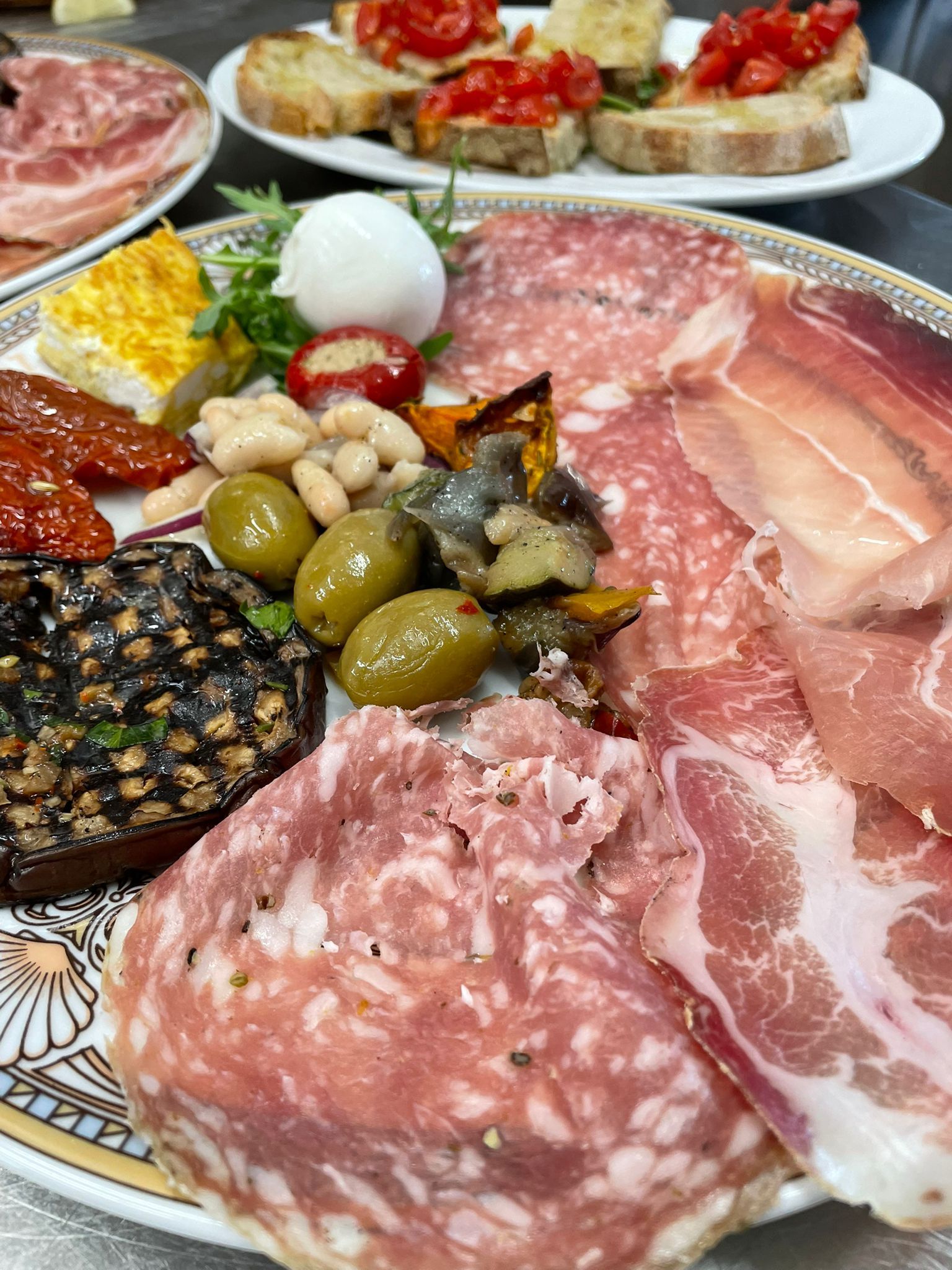 Piatto di salumi con carne, formaggio, olive e verdure.