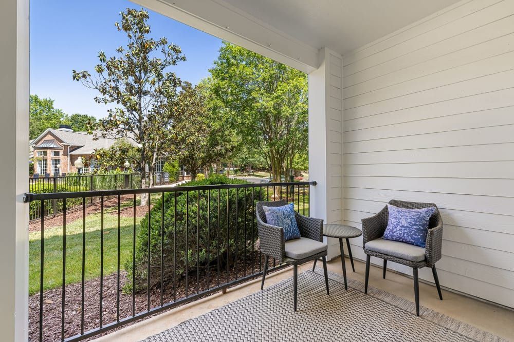 there are two chairs and a table on the balcony at Marquis Carmel Valley in Charlotte, NC.
