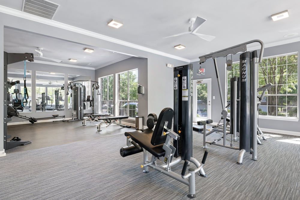 a large gym filled with lots of exercise equipment and a ceiling fan at Marquis Carmel Valley in Charlotte, NC.