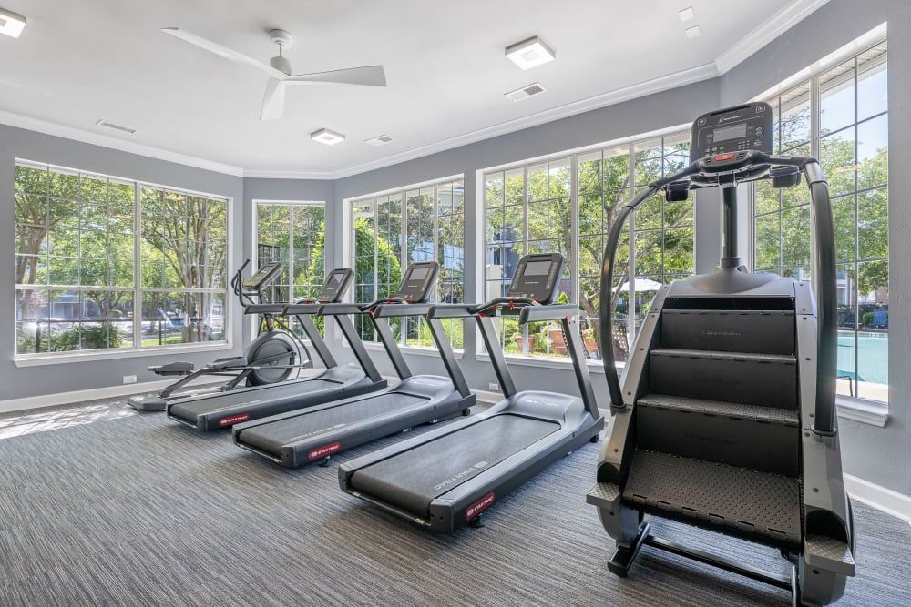a gym with a lot of treadmills and stairs at Marquis Carmel Valley in Charlotte, NC.