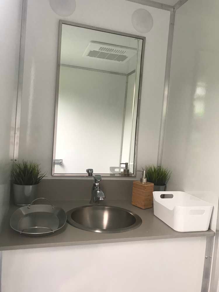 Interior view of a modern bathroom with a mirror, sink, and decor.