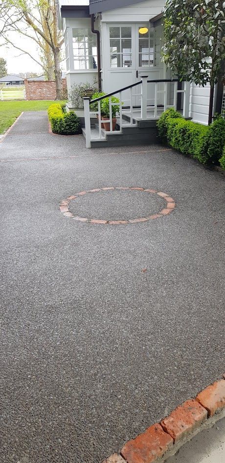 A driveway leading to a house with a circle in the middle of it.