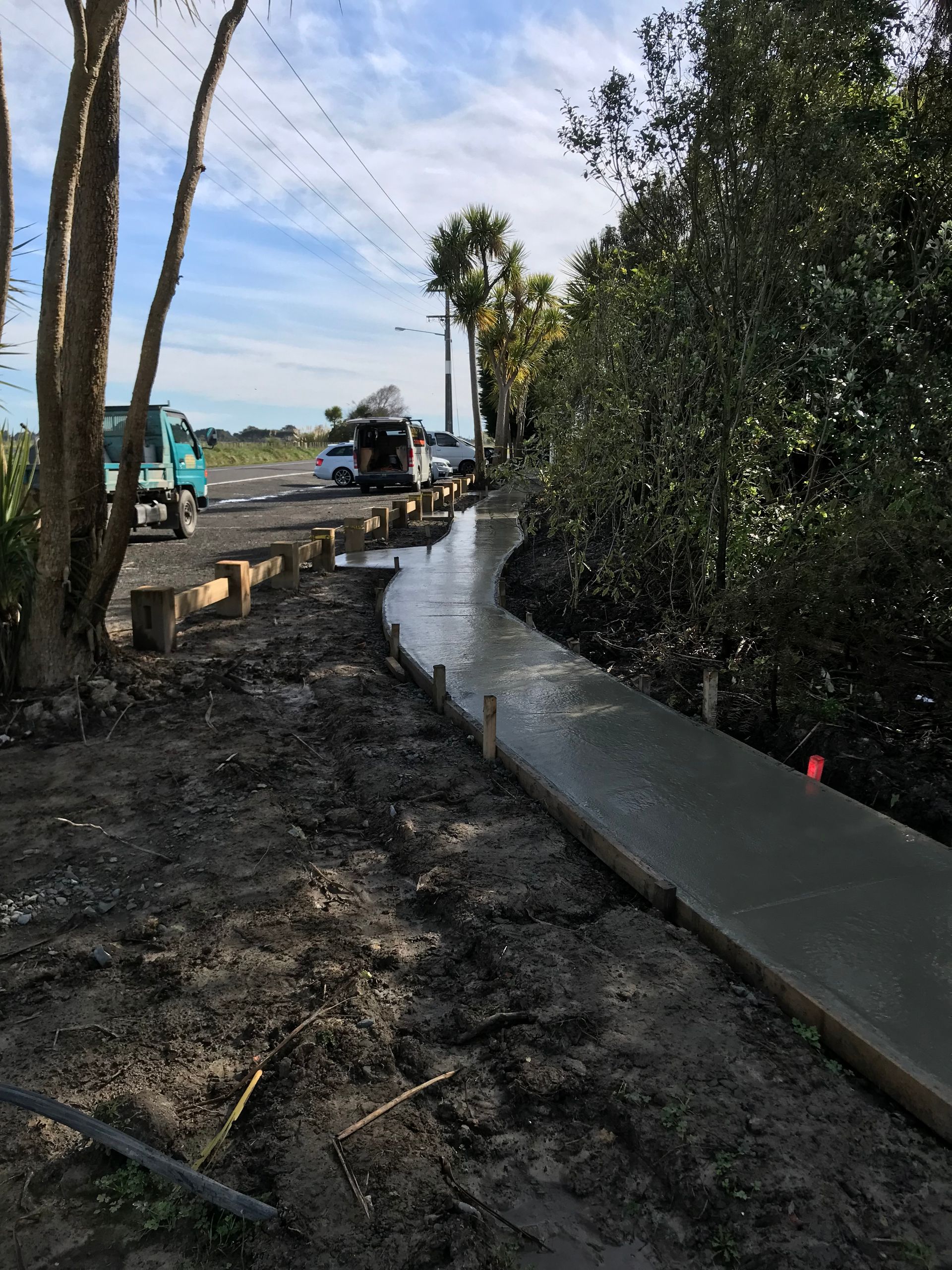 A concrete walkway is being built in the middle of a dirt field.