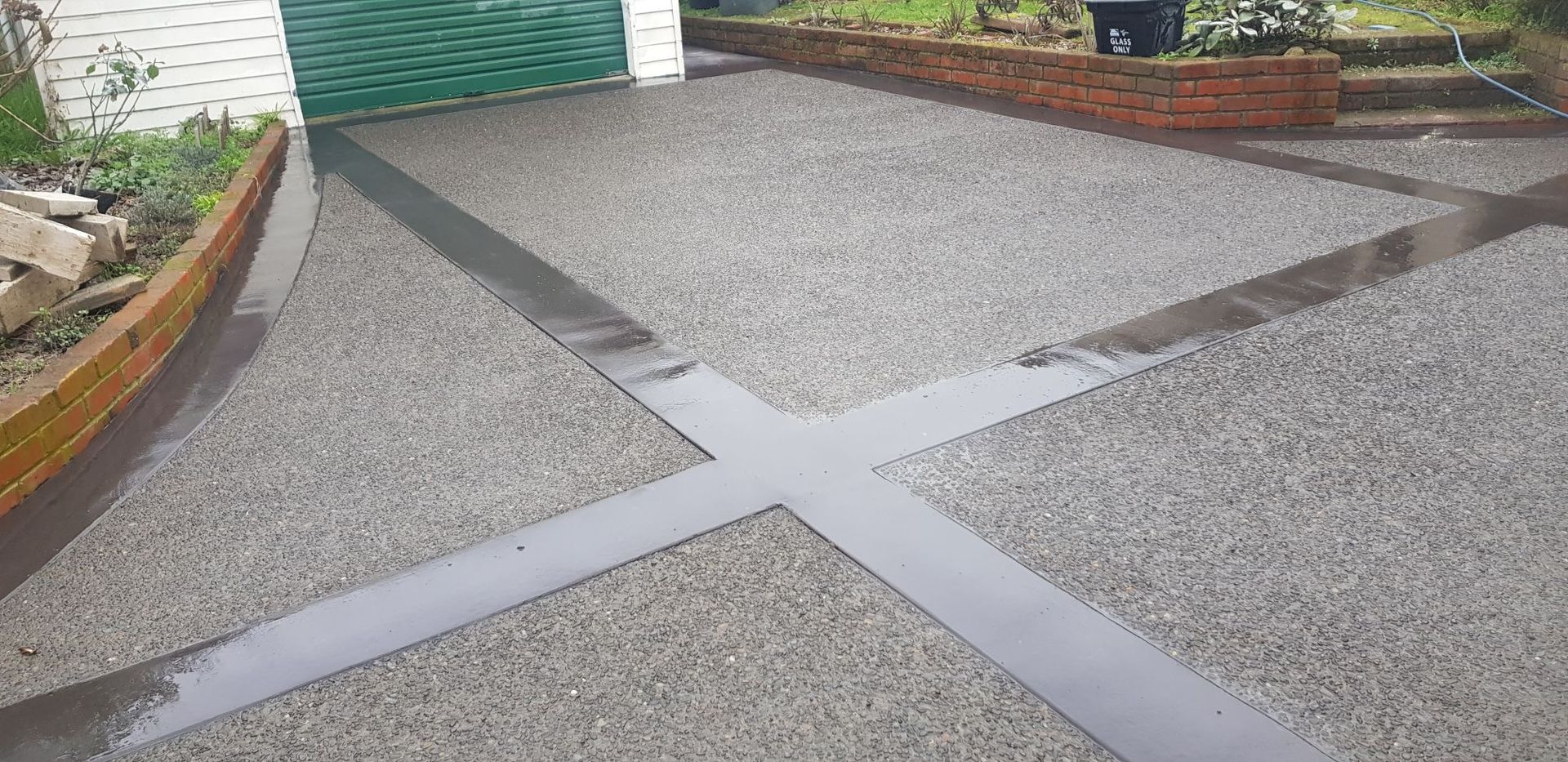A concrete driveway with a cross in the middle of it.