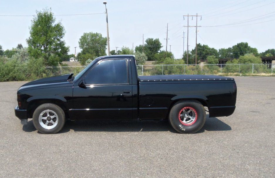 A black pickup truck is parked in a parking lot.