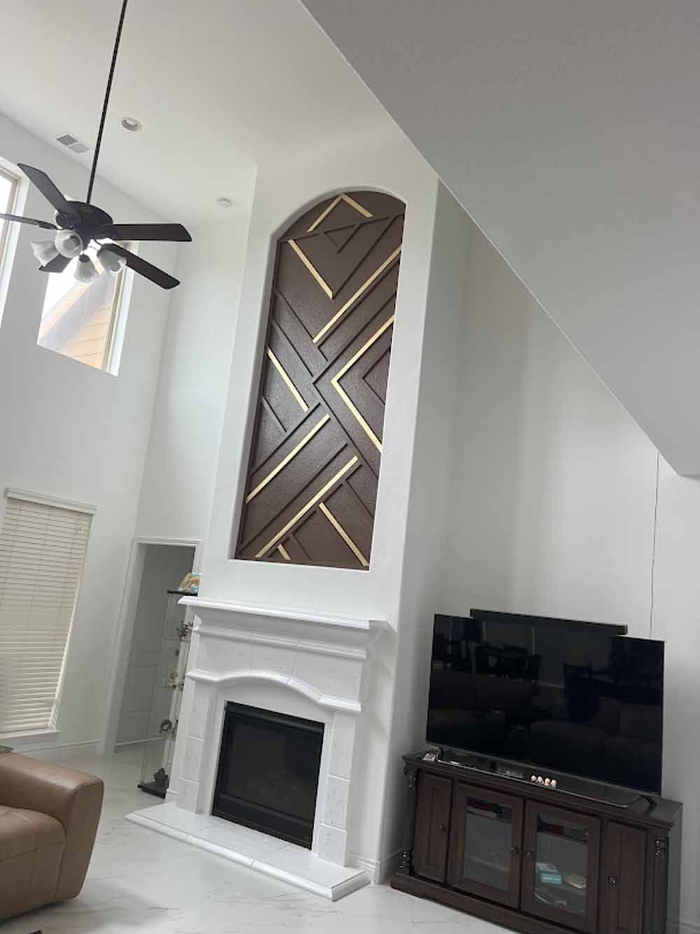 Living room with a fireplace, large decorative wooden panel, and TV.