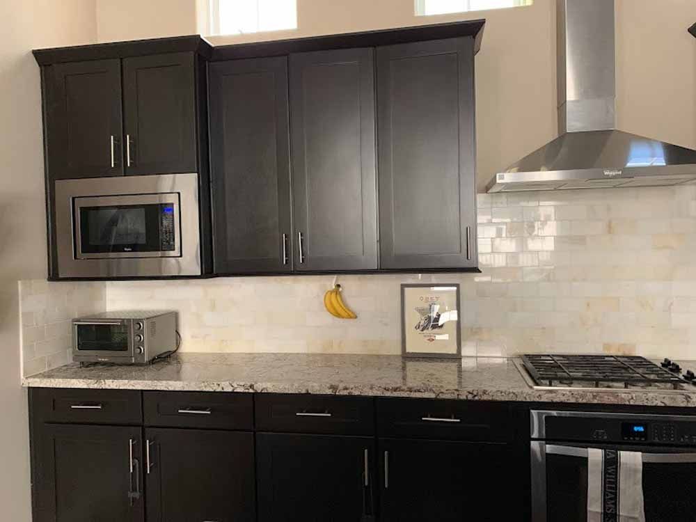 Dark wood kitchen cabinets with stainless steel appliances.