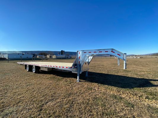 A flatbed trailer is parked in the middle of a field.