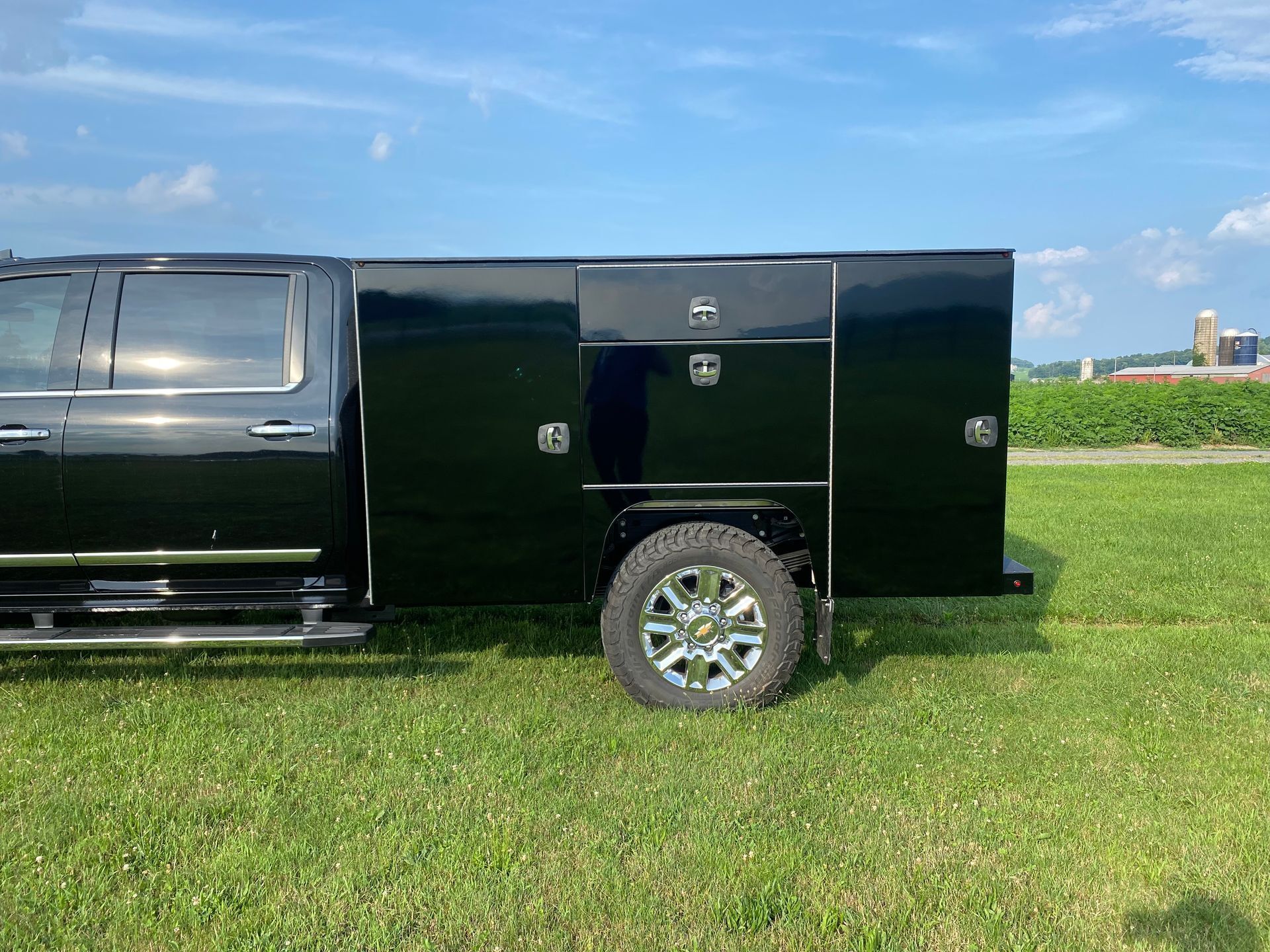 A black truck is parked in a grassy field.