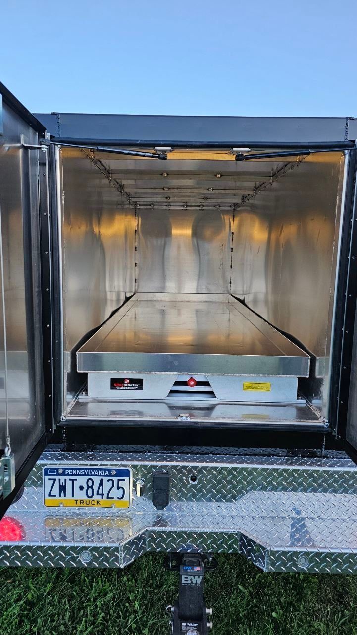 The back of a truck with the door open and a license plate.