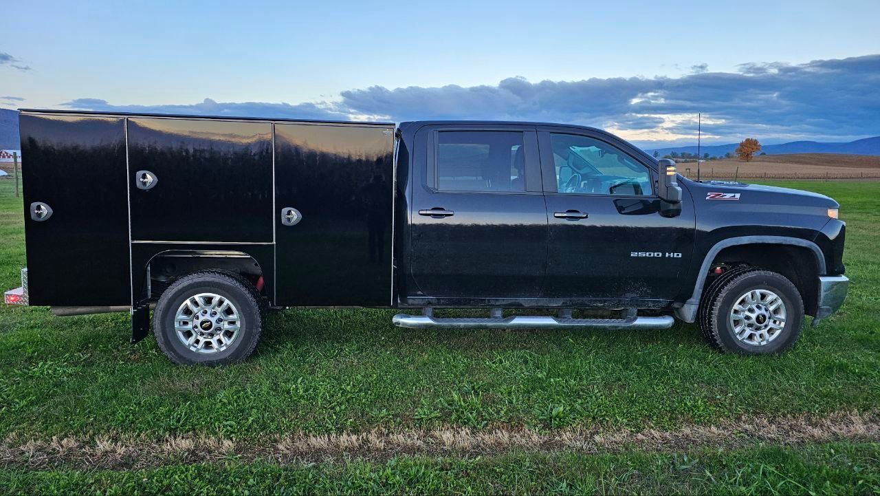 A black truck is parked in a grassy field.