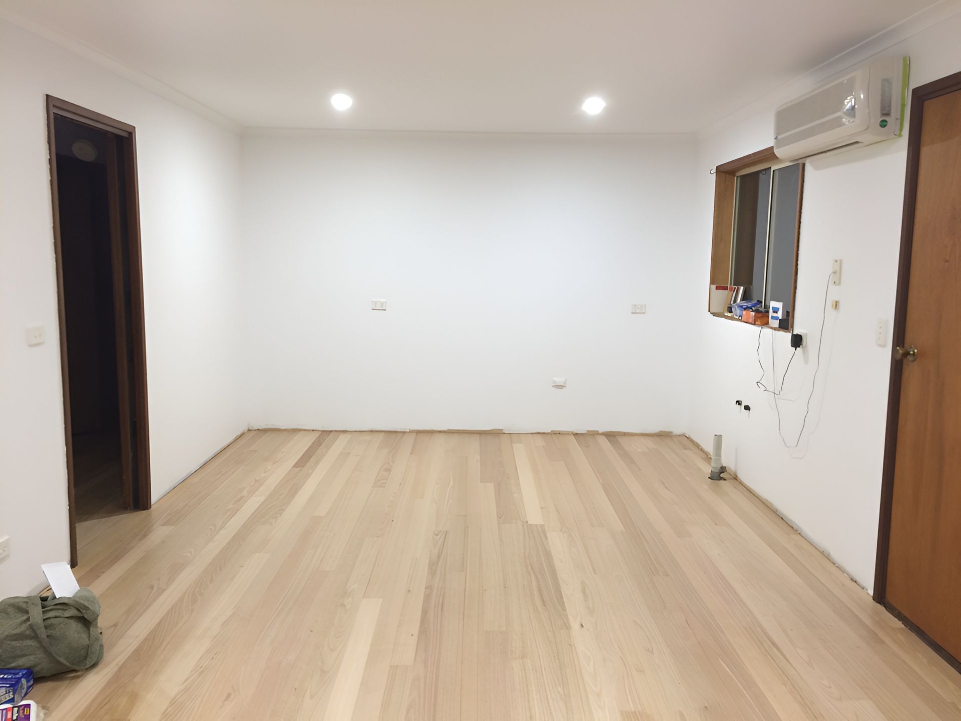 Empty Room with Light Wood Floor, White Walls, Small Window and Open Doorway — Toowoomba Polished Floors in Crows Nest, QLD