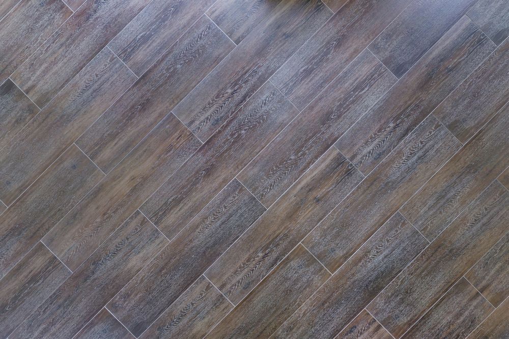 Herringbone-patterned wood-look floor tiles in shades of brown and gray. — Toowoomba Polished Floors in Esk, QLD