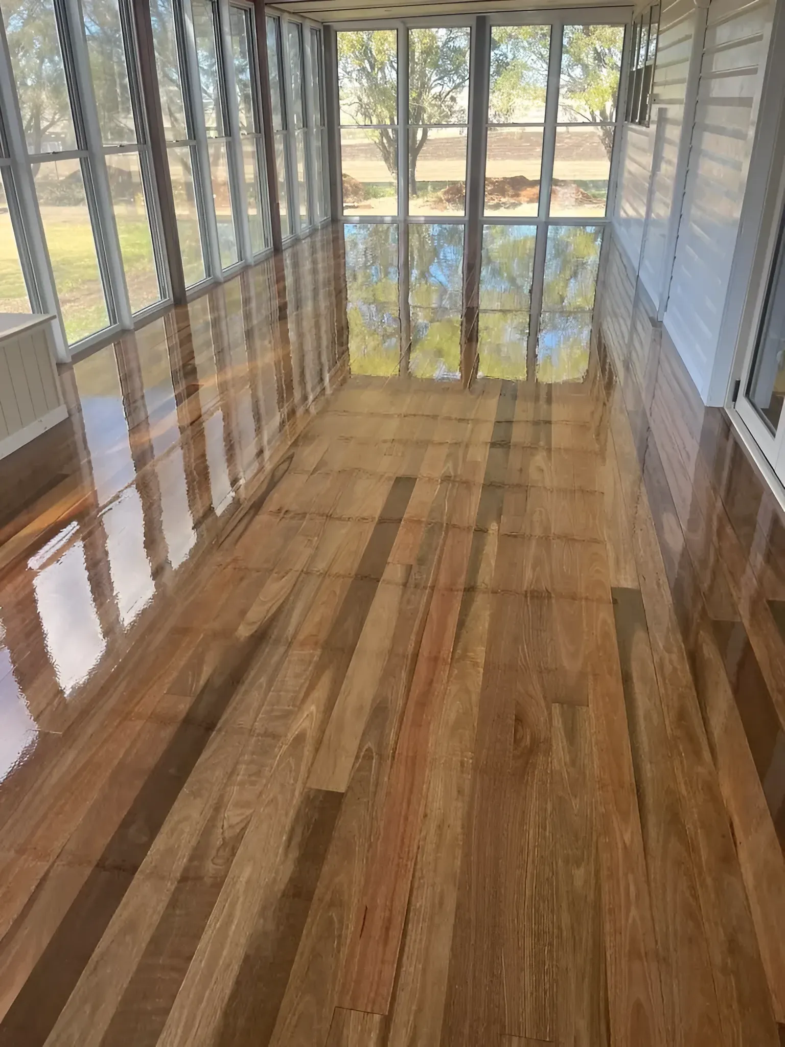Sunroom with Glossy Wood Floor Reflecting the Windows — Toowoomba Polished Floors in Esk, QLD