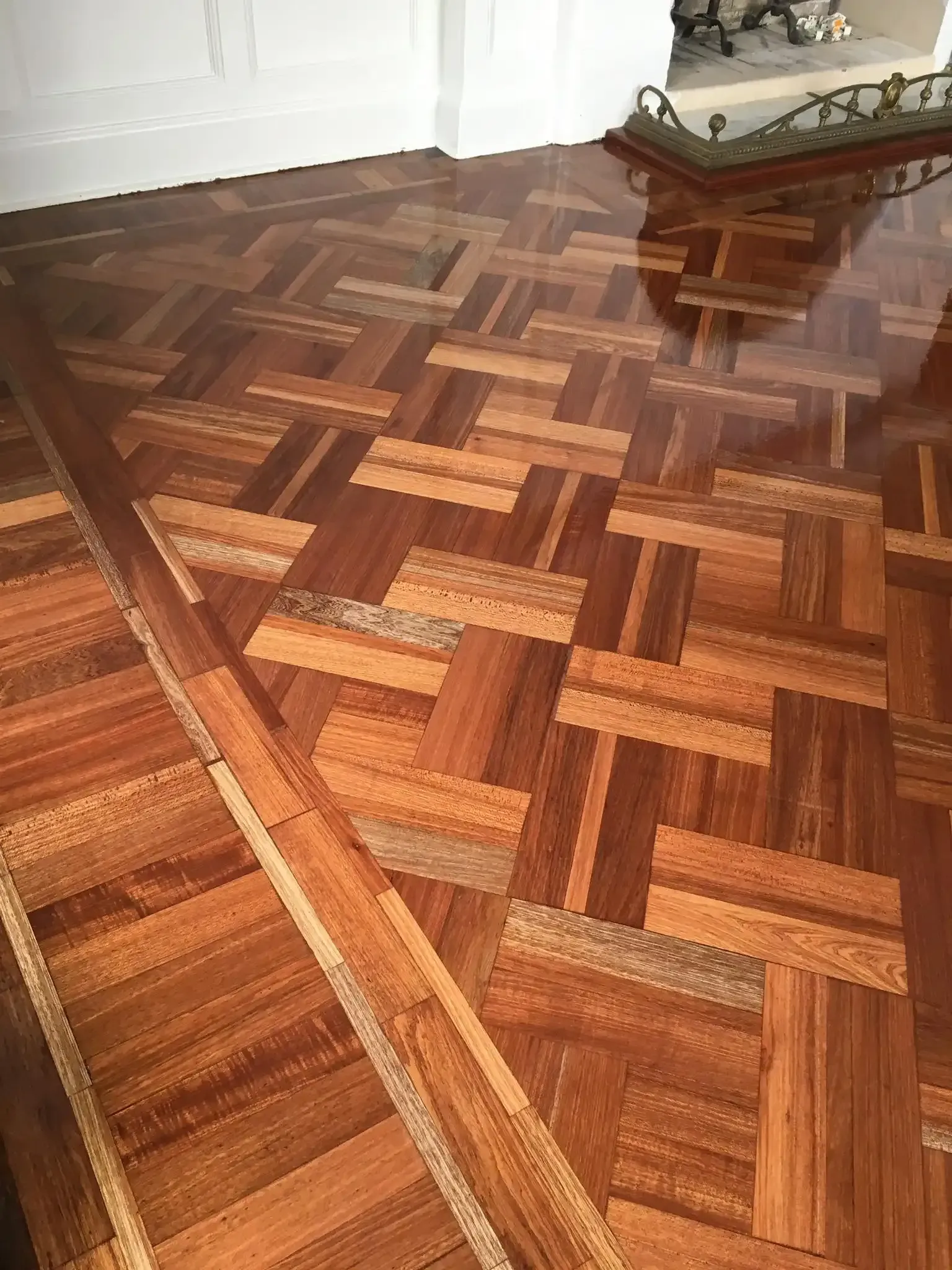 Wooden parquet flooring with a glossy finish, featuring a geometric pattern in various shades of brown. — Toowoomba Polished Floors in Pittsworth, QLD