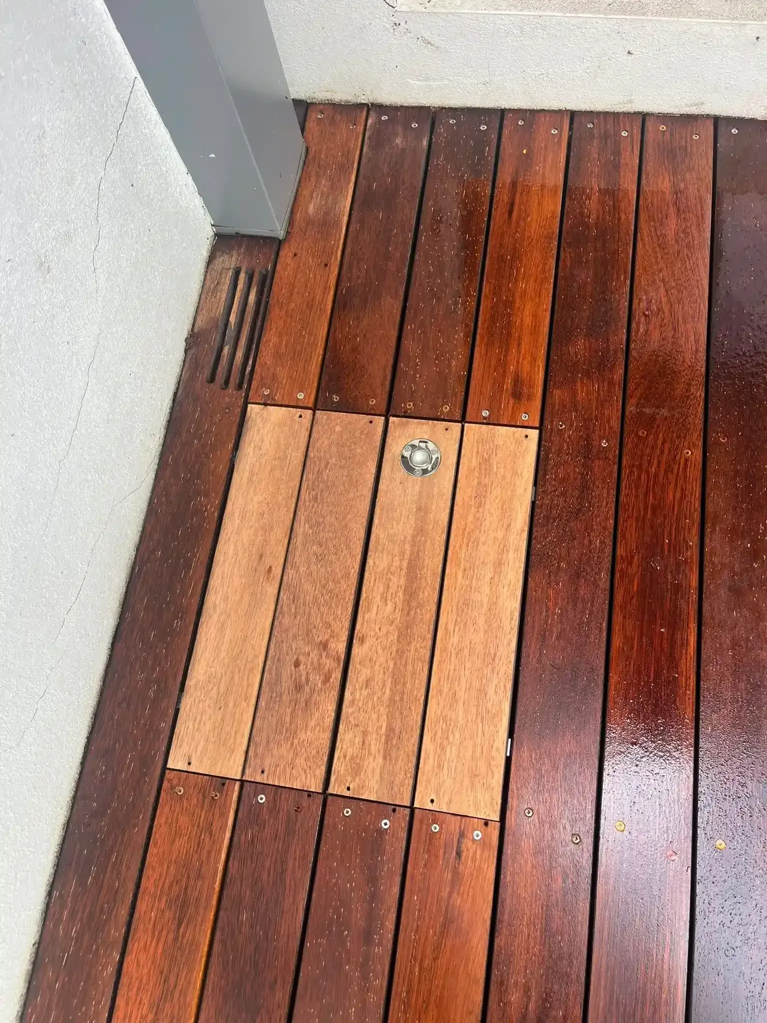 Wooden deck with a smaller, lighter-colored access panel and a metal latch. — Toowoomba Polished Floors in Highfields, QLD