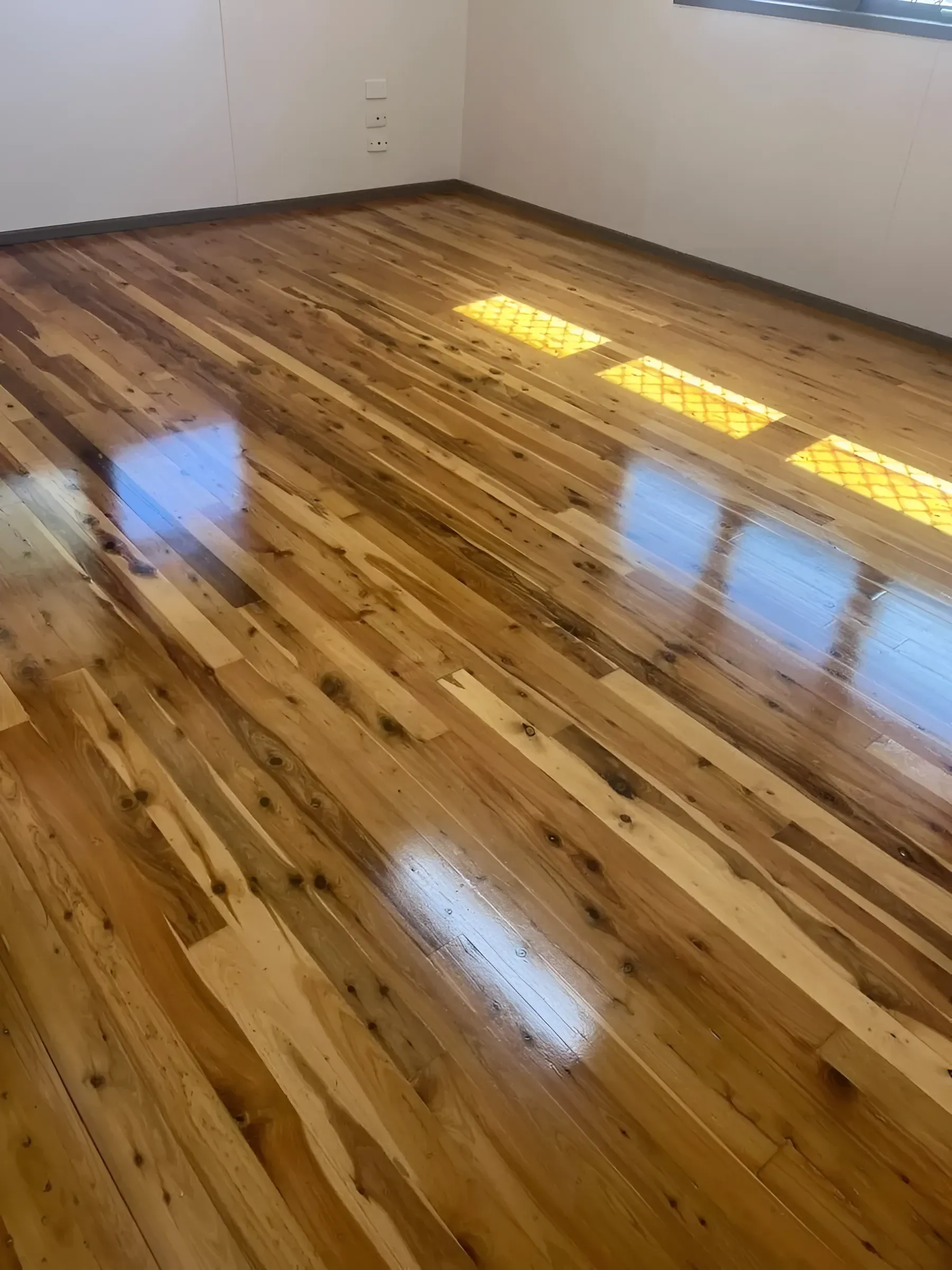 Wooden Floorboards in A Room Reflecting Sunlight — Toowoomba Polished Floors in Pittsworth, QLD