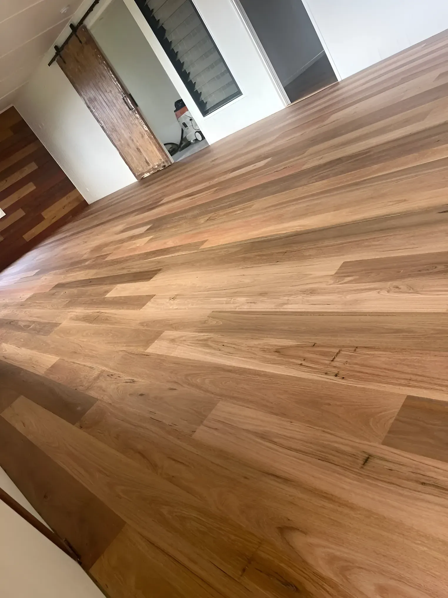 Wooden Floor, Door and A Person in A White Top Looking Down — Toowoomba Polished Floors in Oakey, QLD