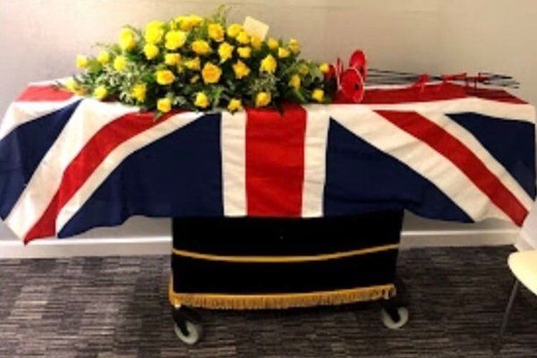 state funeral coffin with yellow flowers
