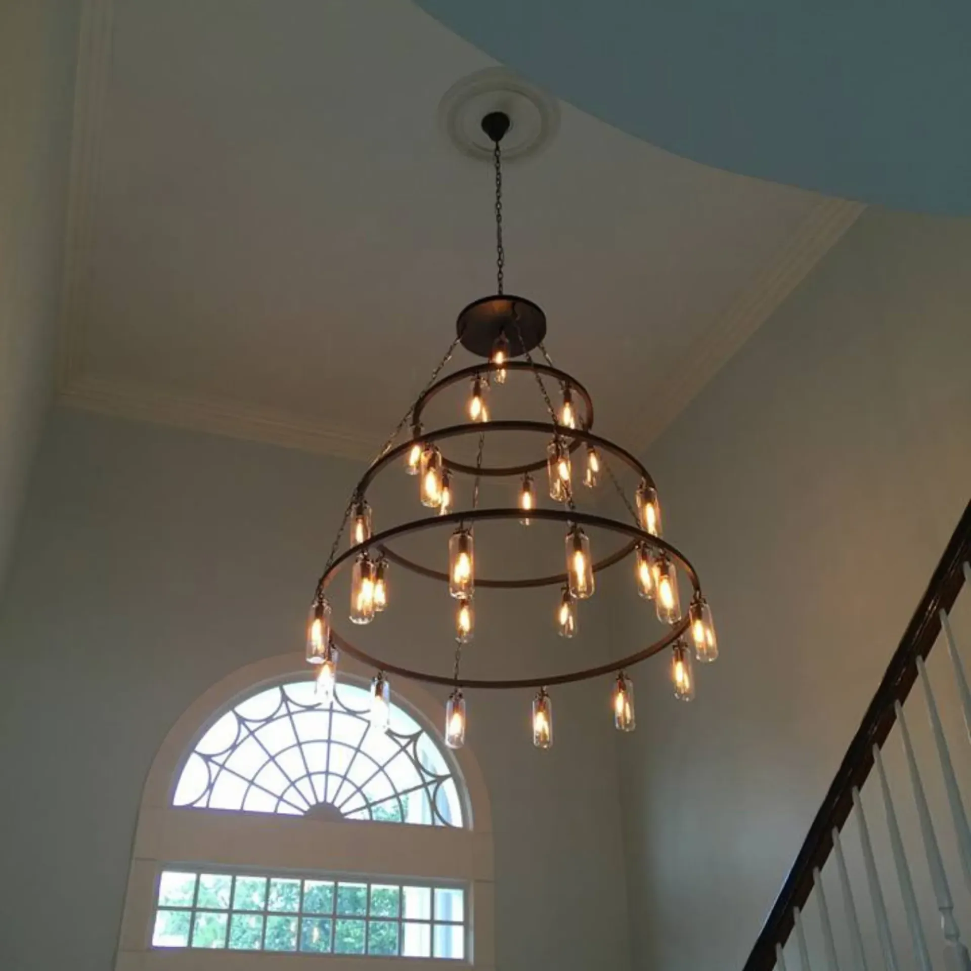 Service of Knights LLC - A staircase with a chandelier hanging from the ceiling
