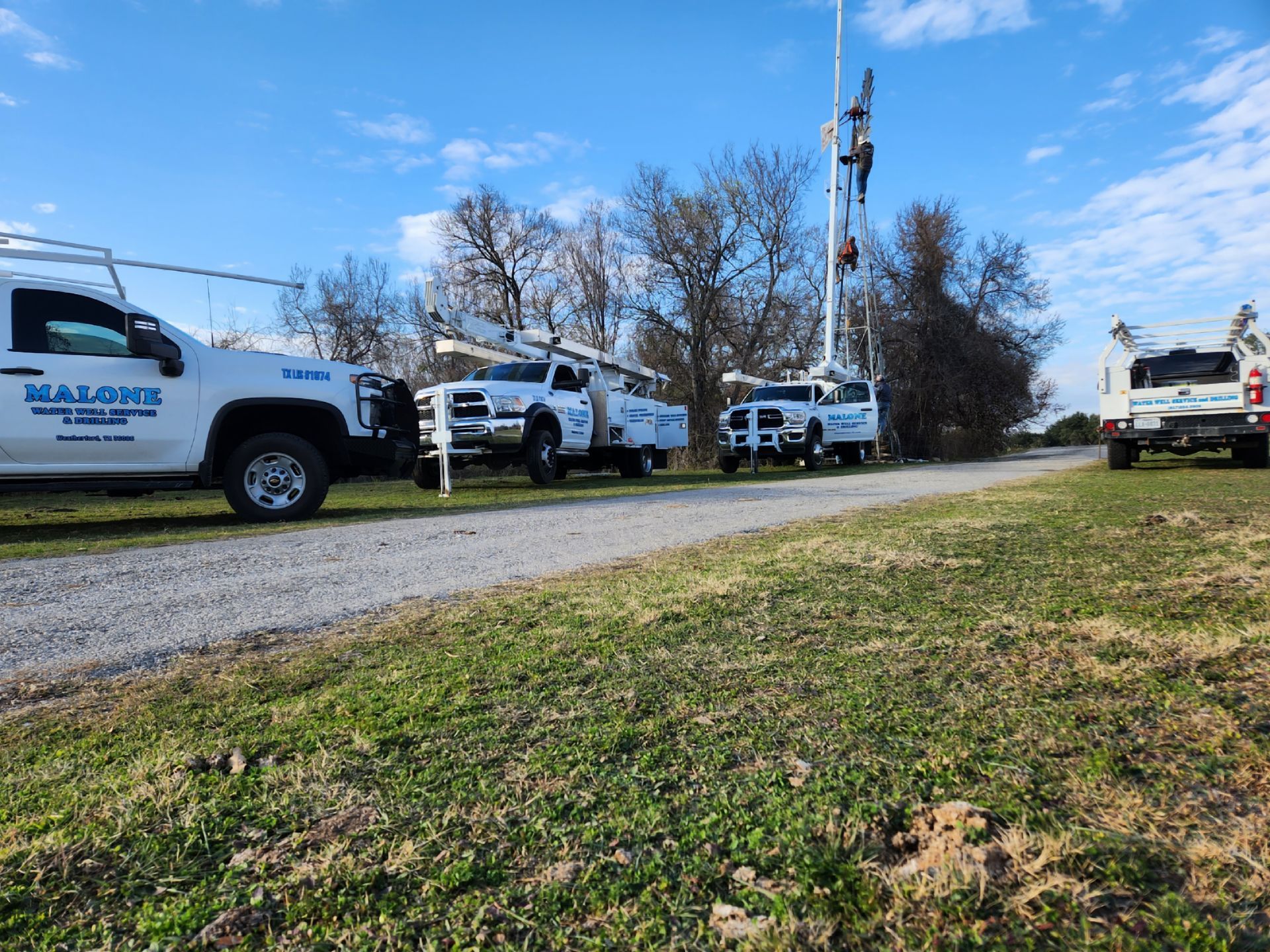 A row of white trucks parked on the side of a road.