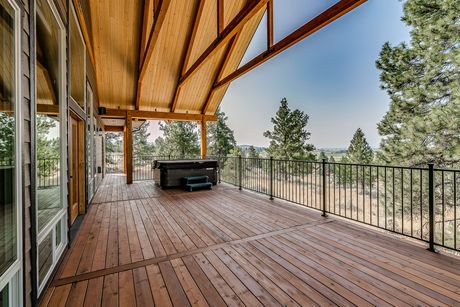 A large wooden deck with a hot tub on it.