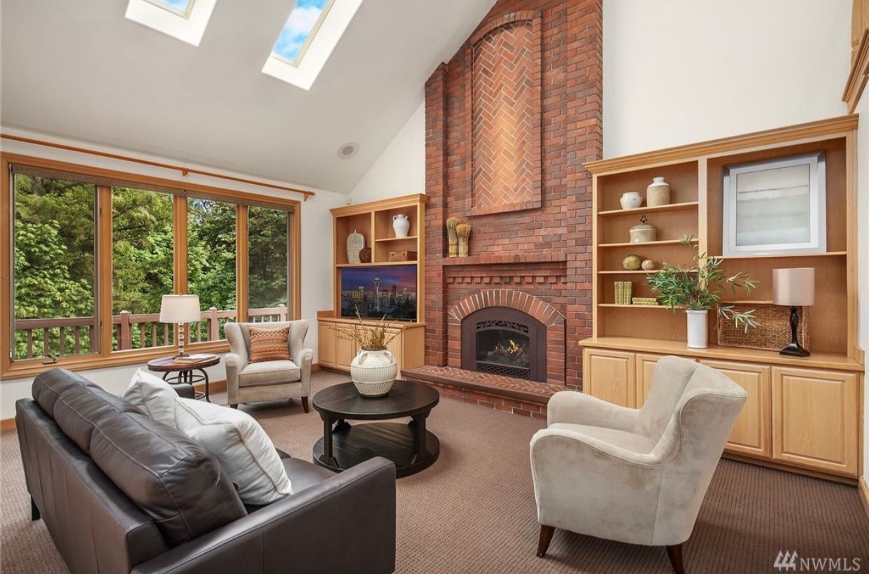 A living room with a brick fireplace and a couch and chairs