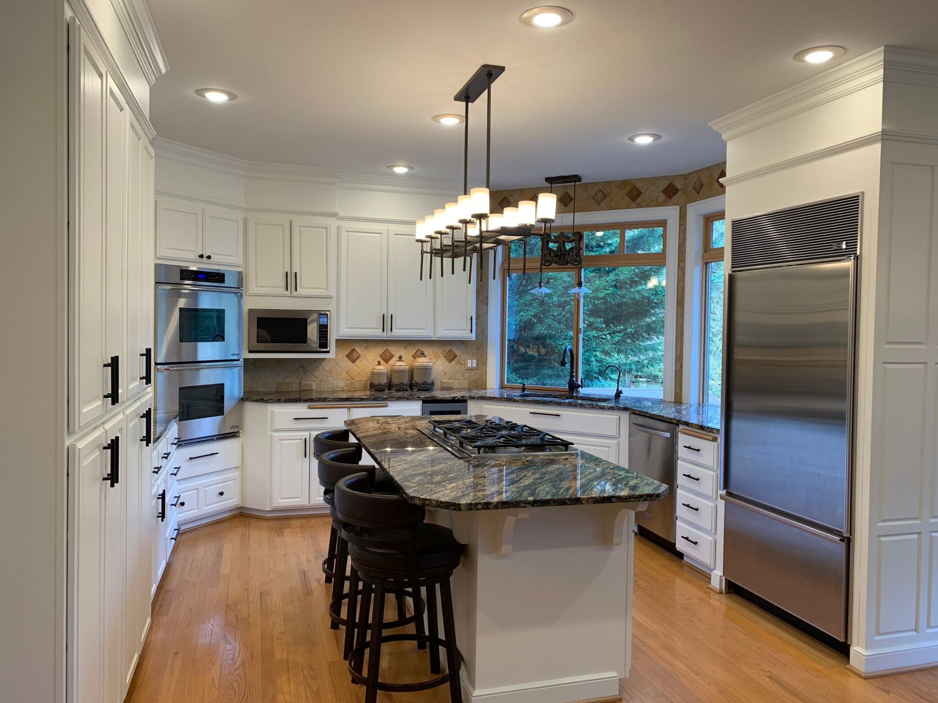 A kitchen with white cabinets and stainless steel appliances