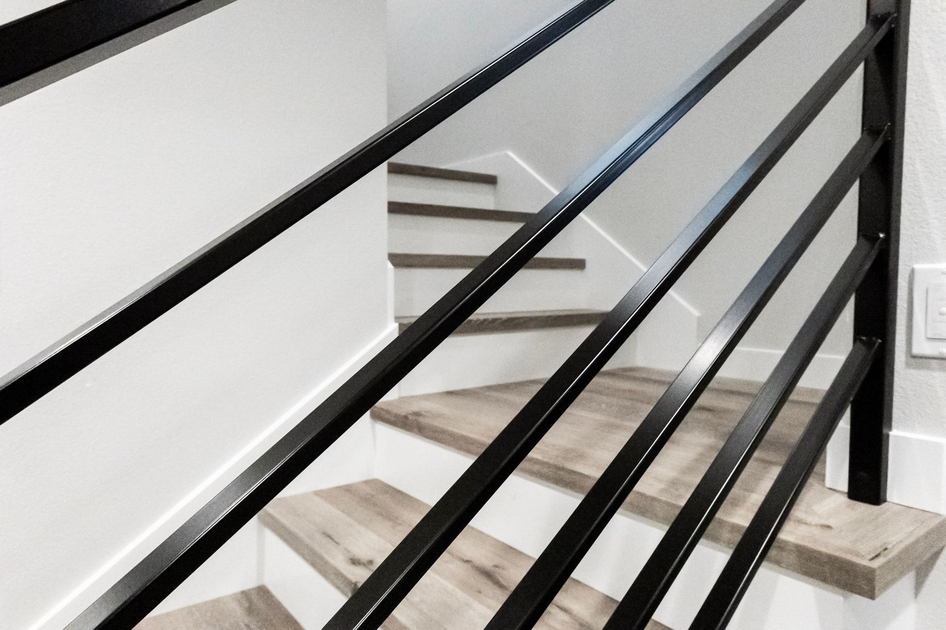 A close up of a staircase with a black railing