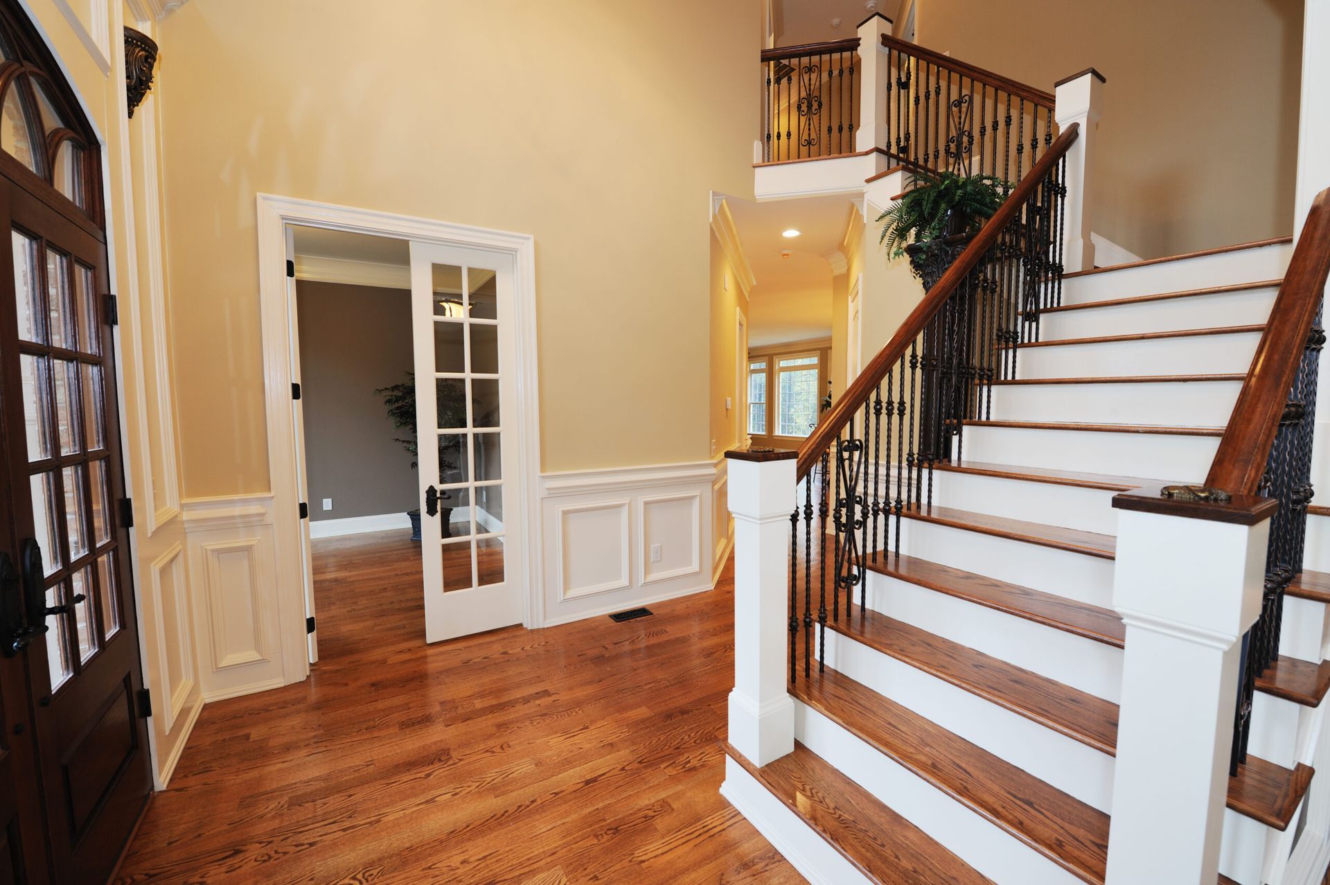 A hallway with hardwood floors and stairs in a house