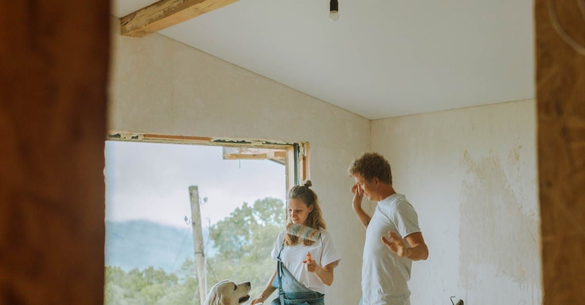 A man and a woman are standing in a room with a dog.