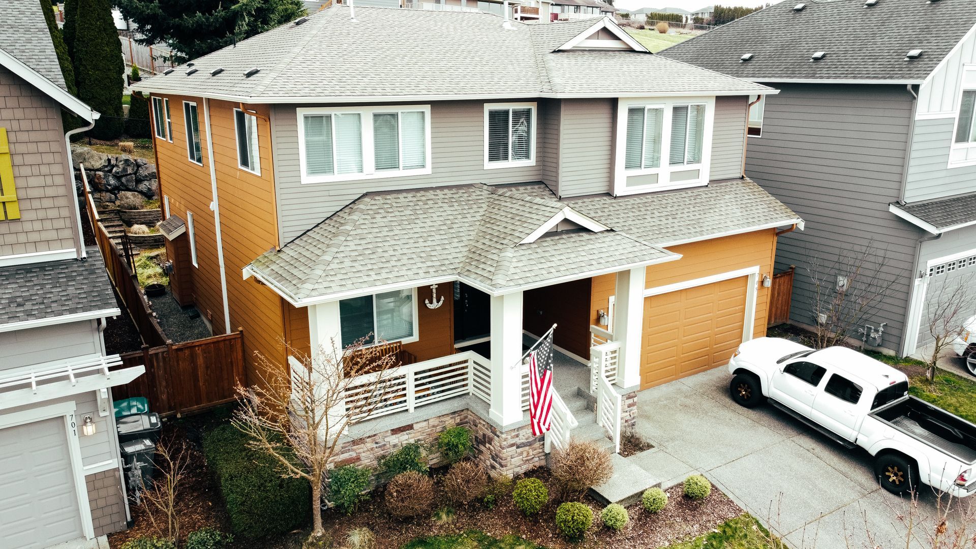 An aerial view of a house with a white truck parked in front of it.