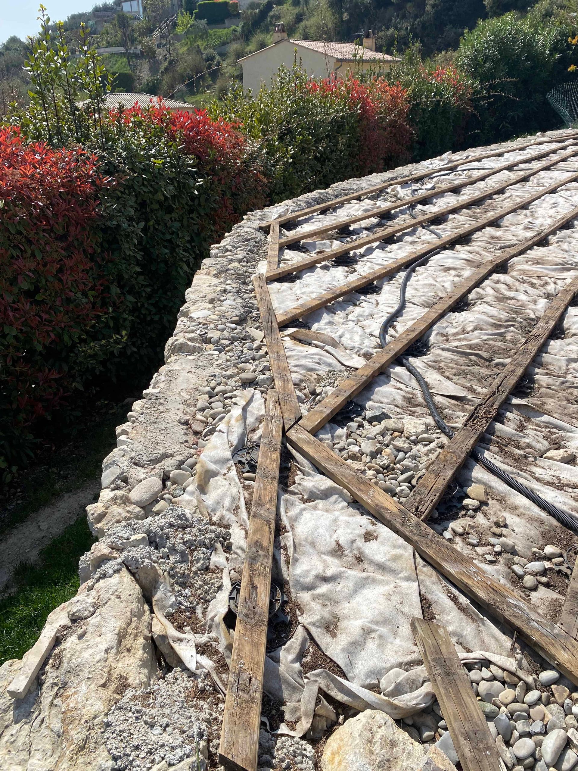 Un mur de pierre avec des poutres en bois posées dessus.