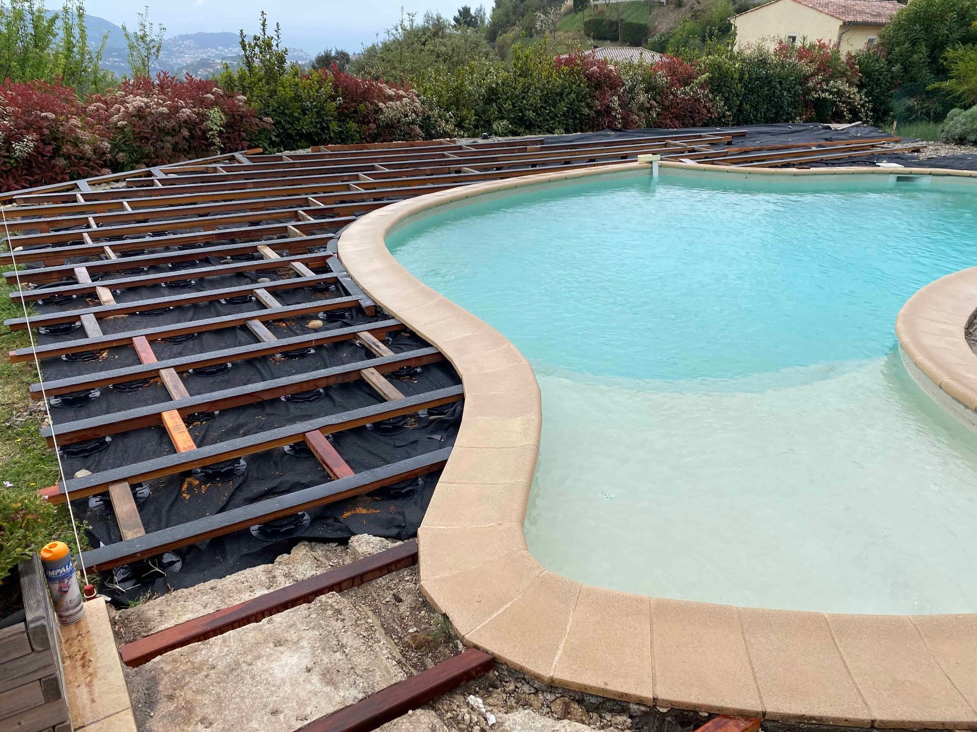 Une piscine avec une terrasse en bois autour