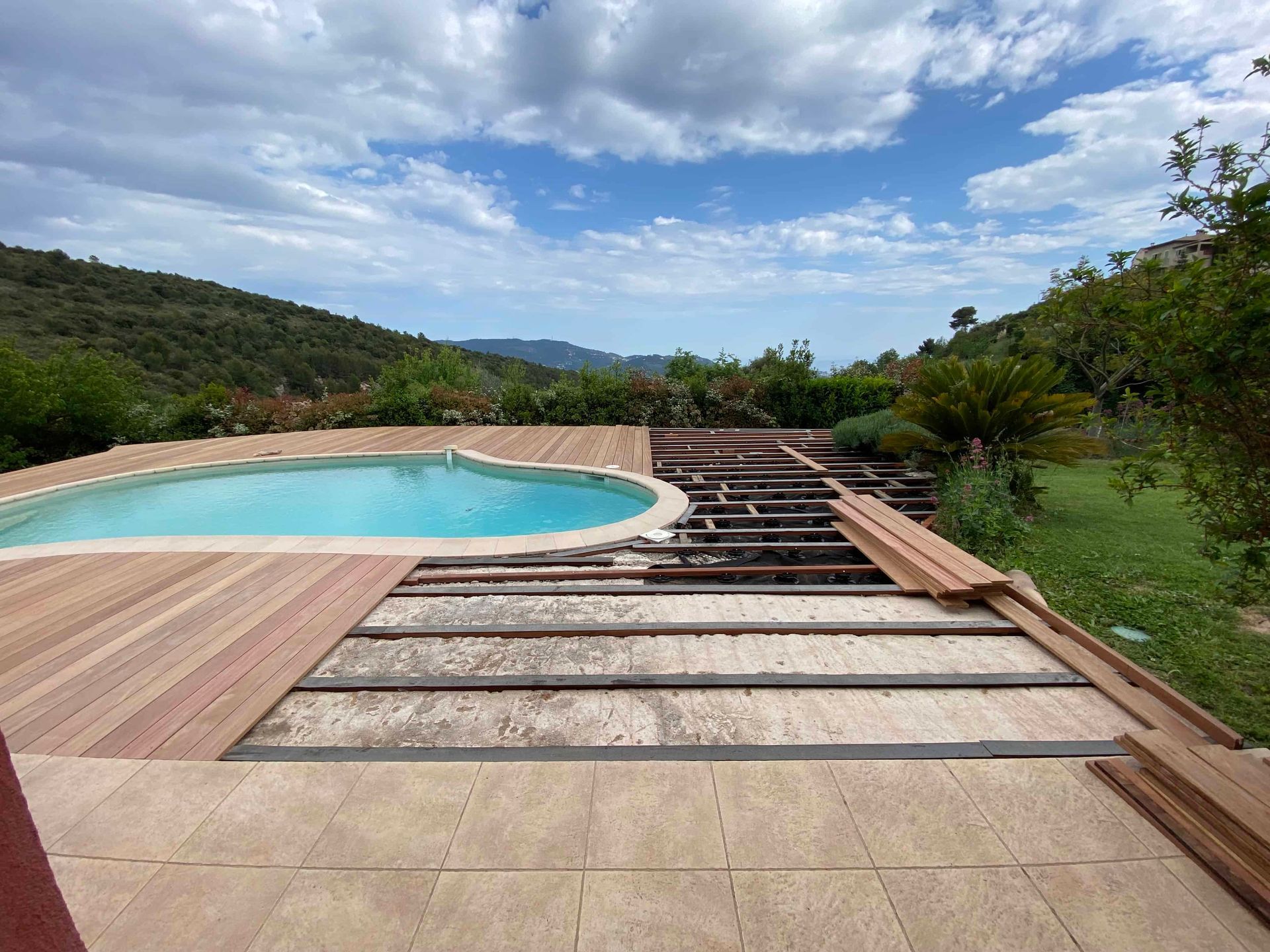 Une grande piscine est entourée d'une terrasse en bois.
