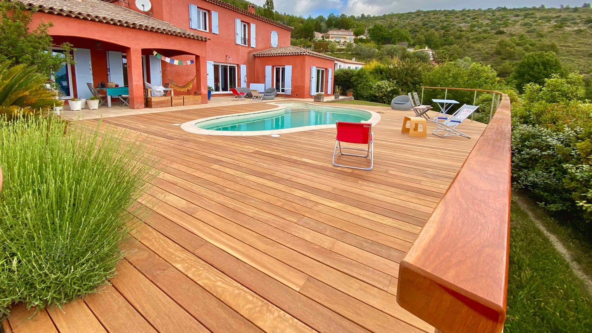 Une grande maison avec une piscine et une terrasse en bois