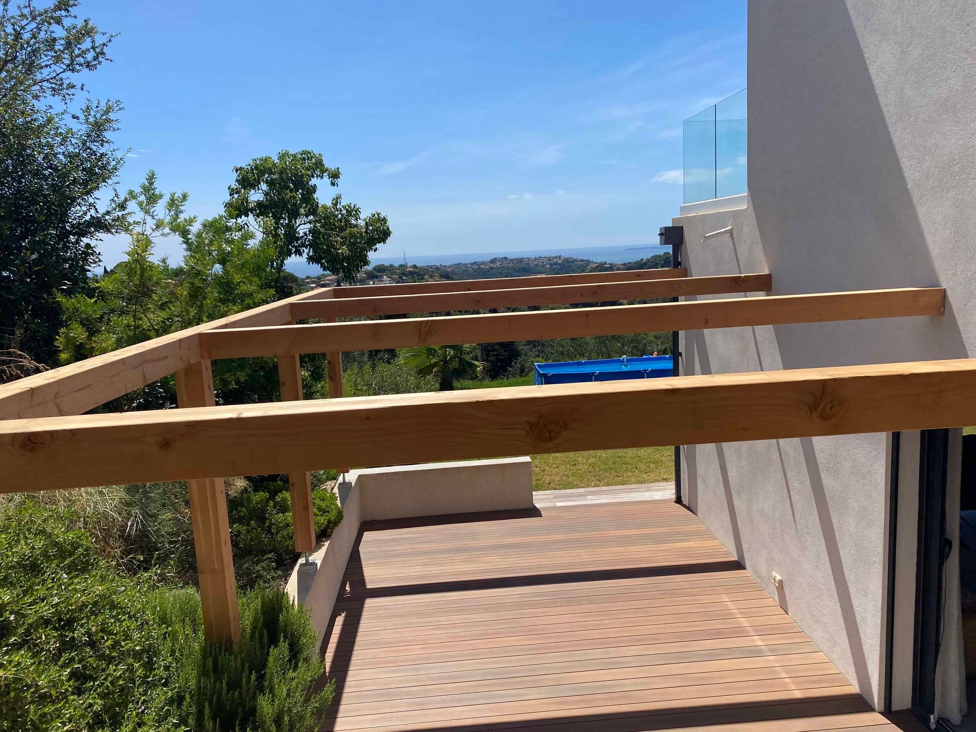 Une pergola en bois est en train d'être construite sur le côté d'une maison.