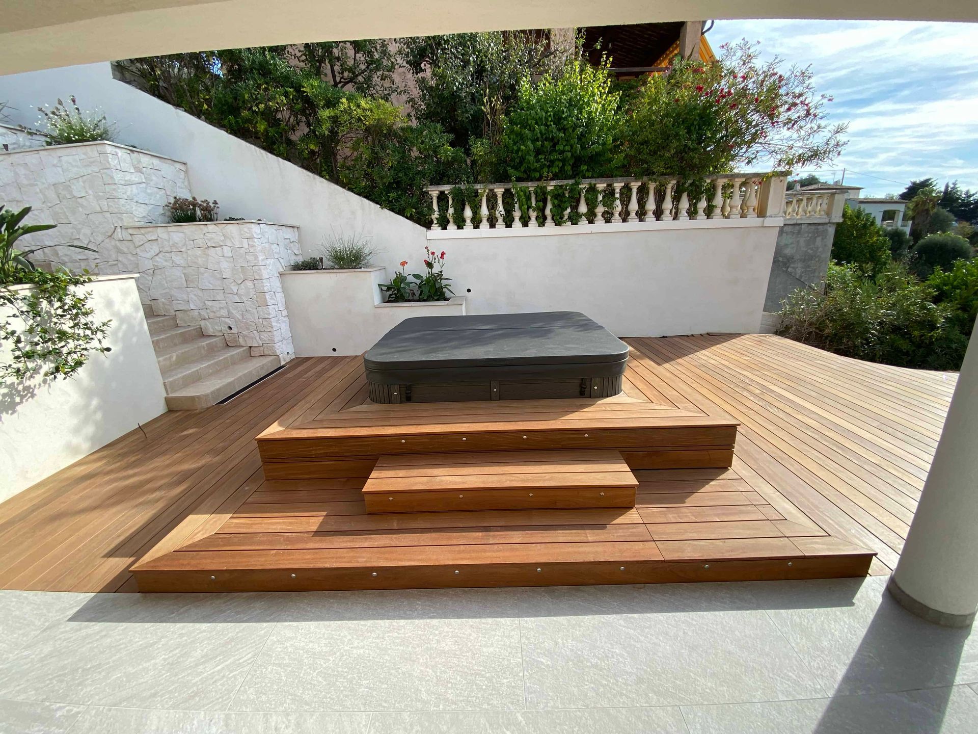 Une terrasse en bois avec des escaliers et un bain à remous dessus