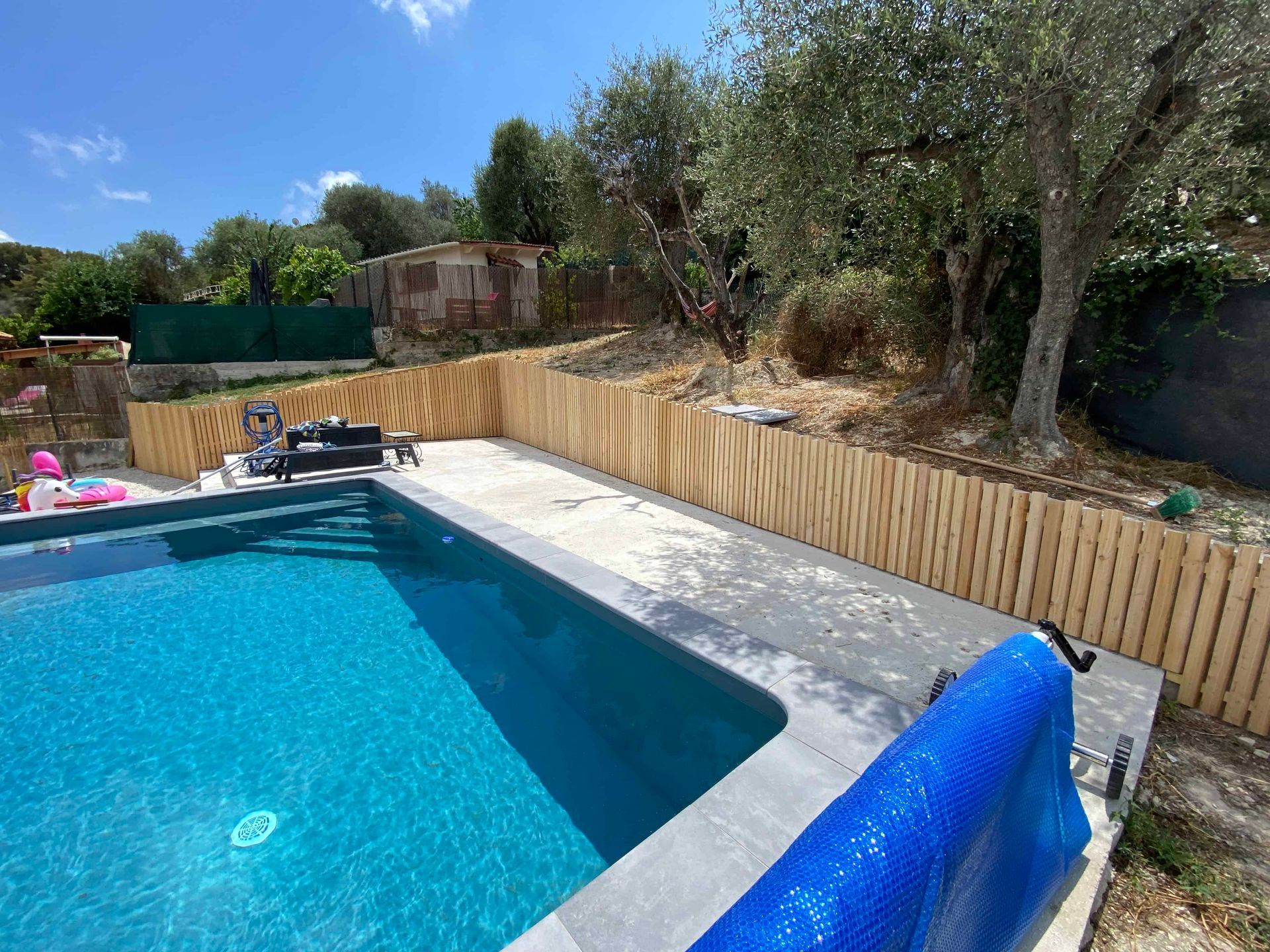 Une grande piscine entourée d'une clôture en bois