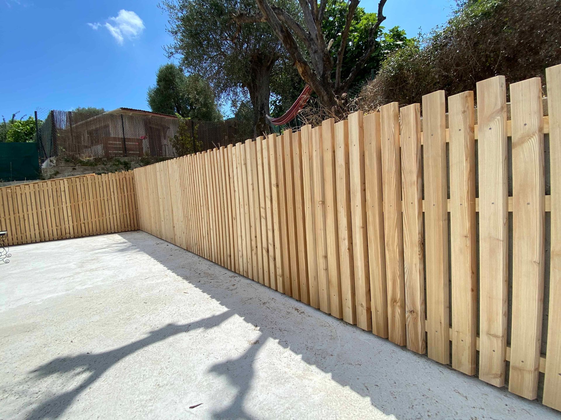 Une clôture en bois avec un arbre en arrière-plan