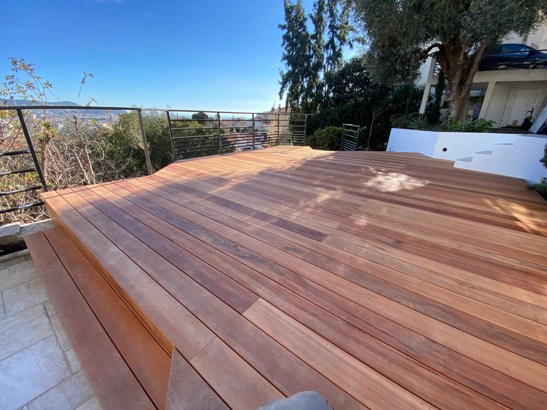 Une terrasse en bois avec vue sur l'océan et les arbres