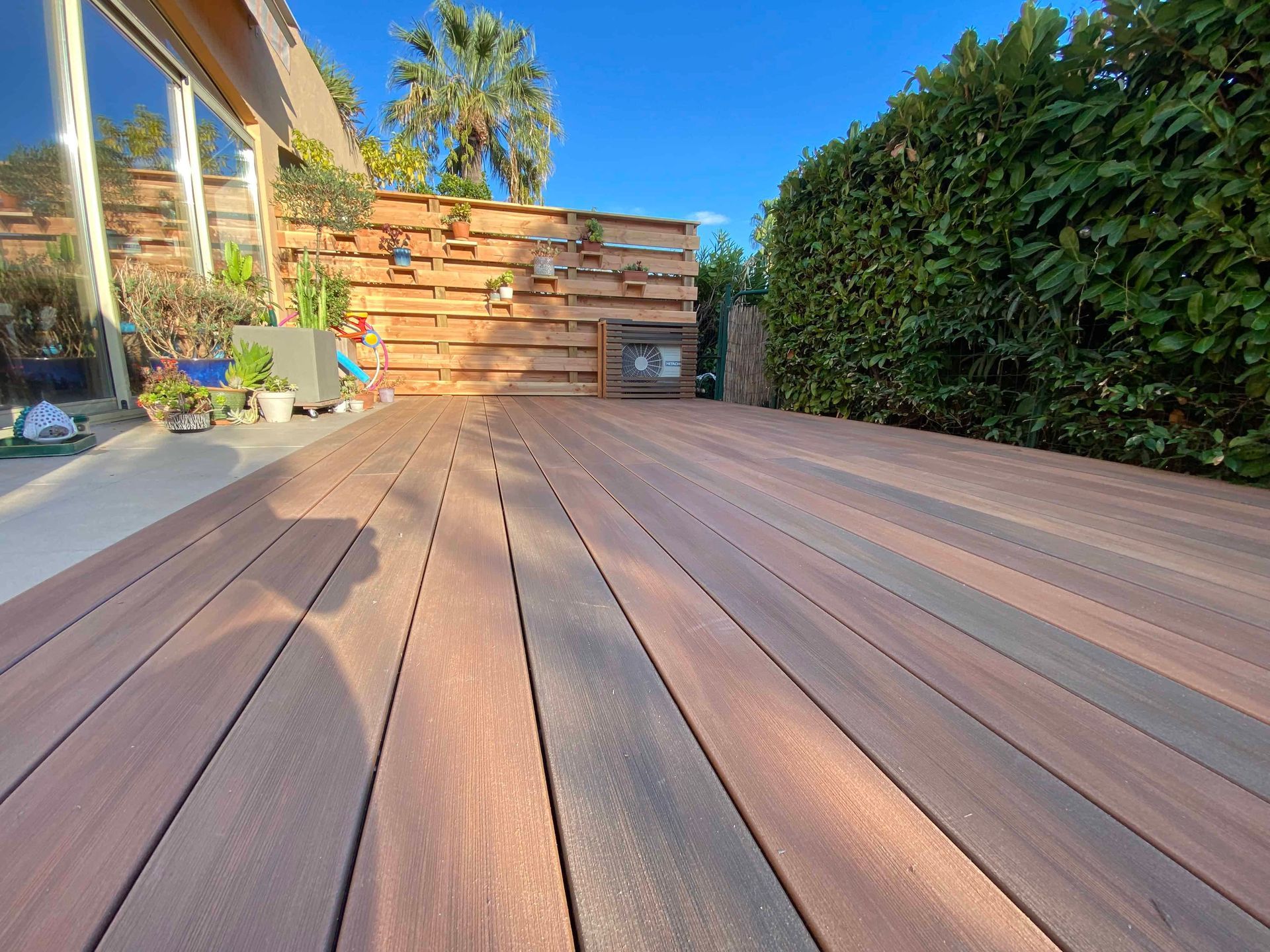 Une terrasse en bois avec une clôture en arrière-plan