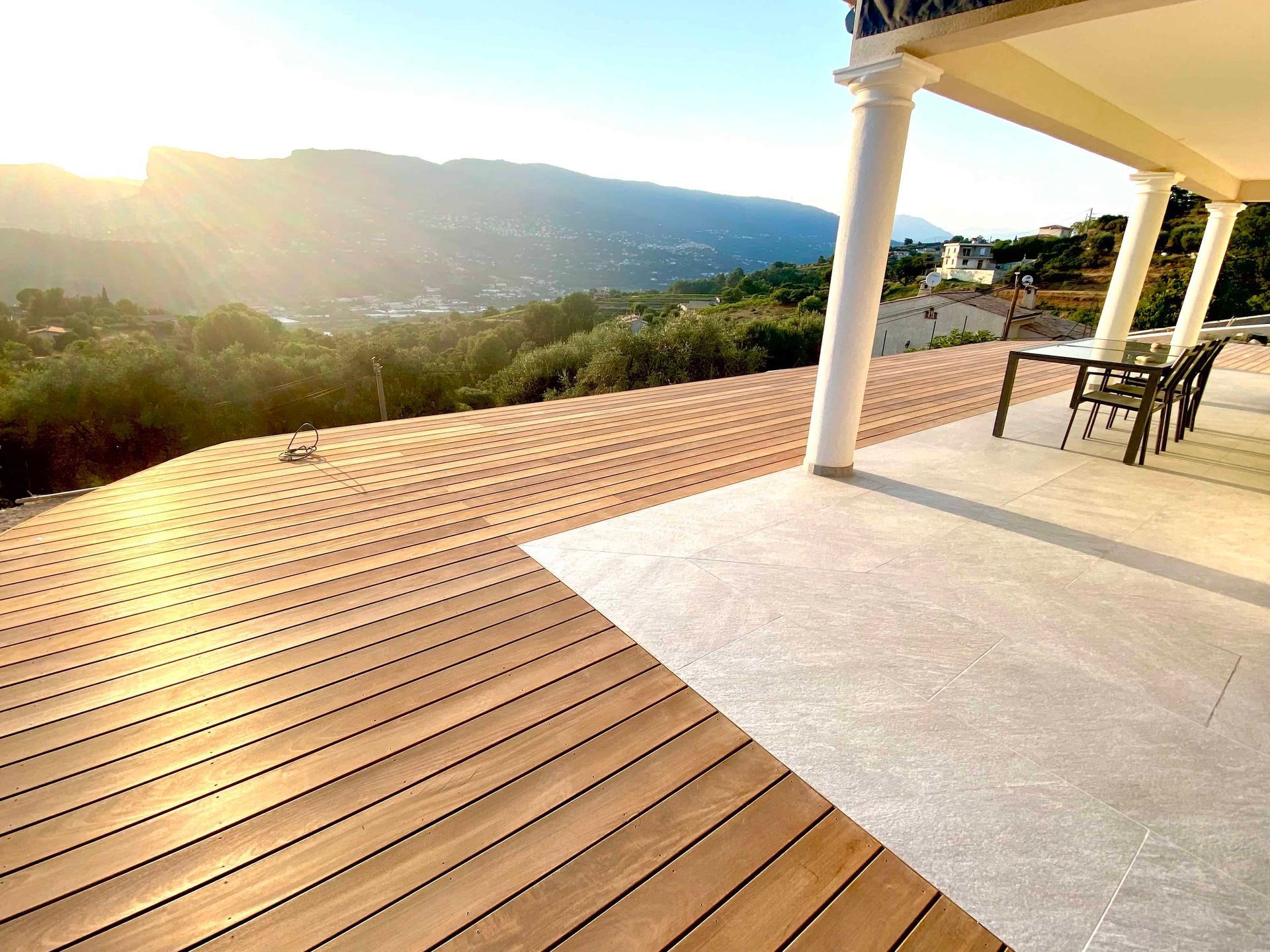 Une terrasse en bois avec une table et des chaises dessus