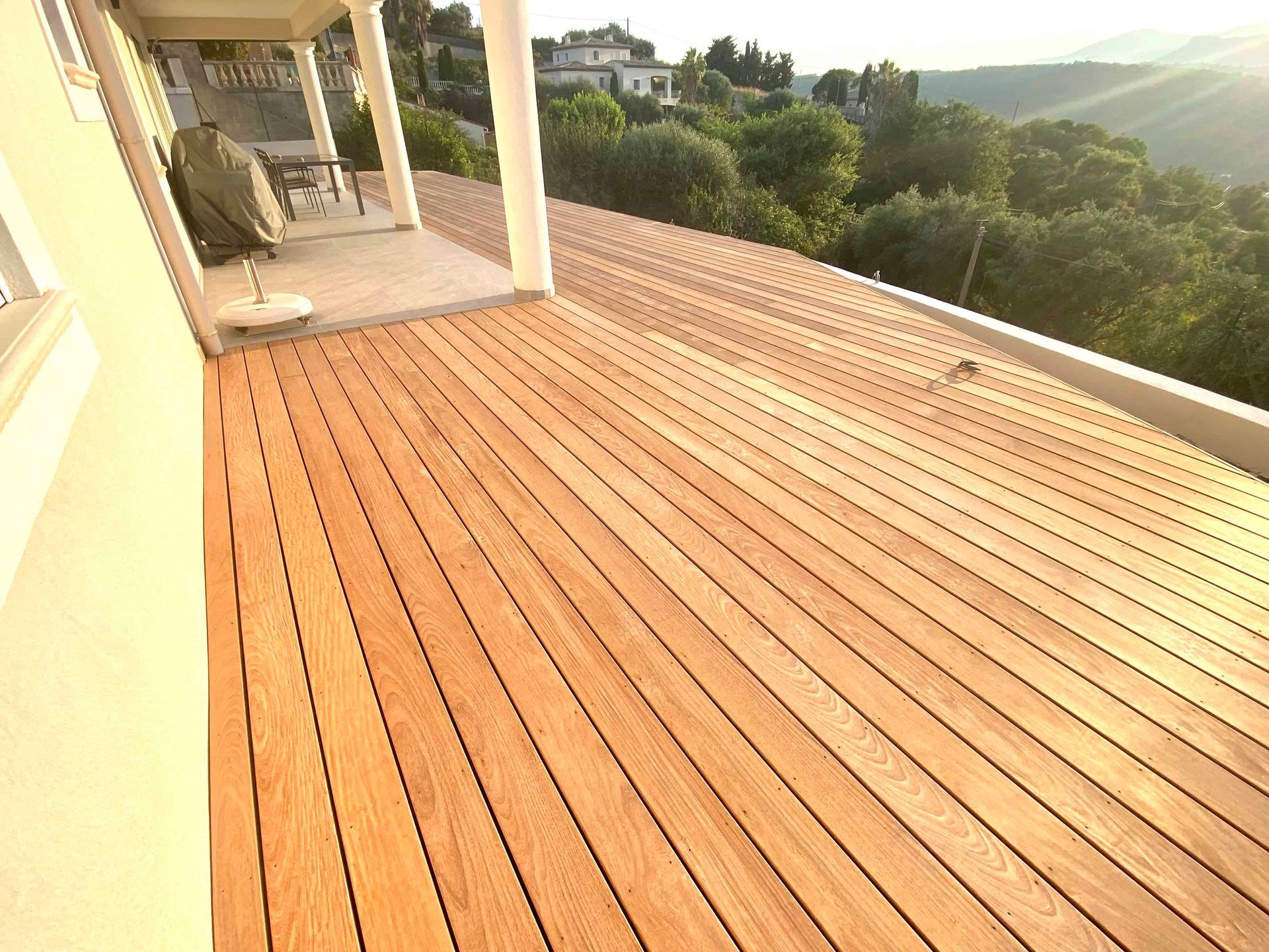 Une terrasse en bois avec vue sur les arbres et les montagnes