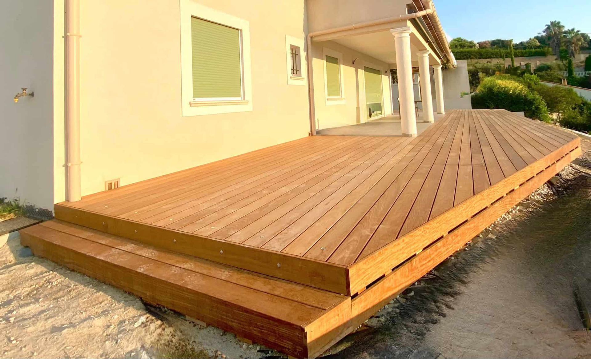 Une grande terrasse en bois se trouve devant une maison