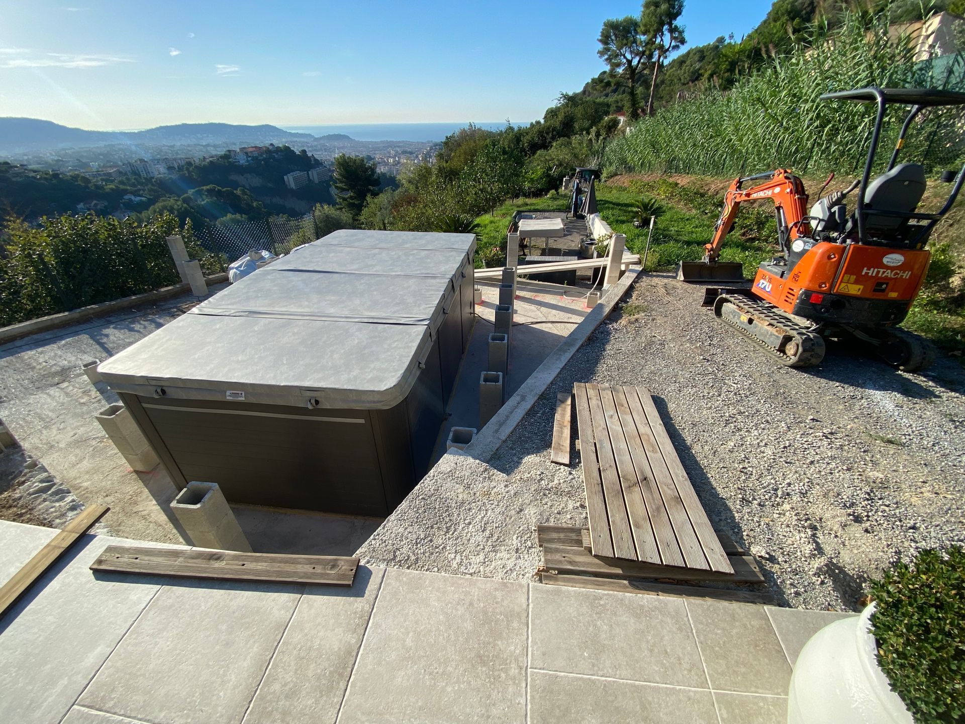 Un bain à remous est en cours de construction à côté d'une petite excavatrice.