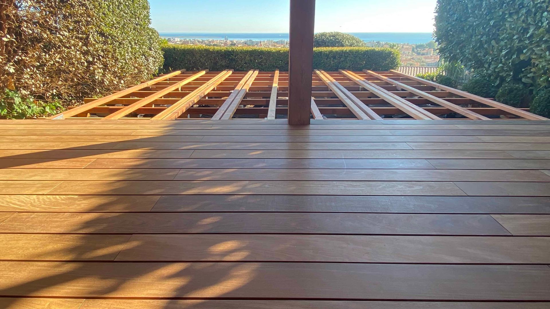 Une terrasse en bois avec vue sur l'océan.